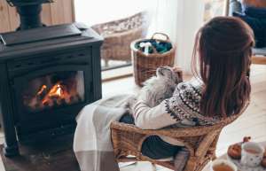 Woman with cat sitting in front of fireplace