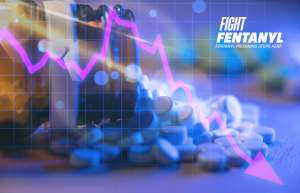 Bottle of pills spilled out with a declining line graph overlaid